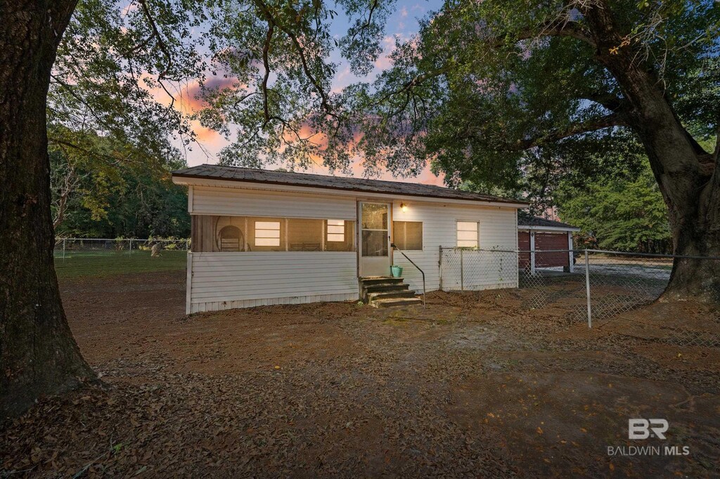 view of front of property featuring entry steps and fence