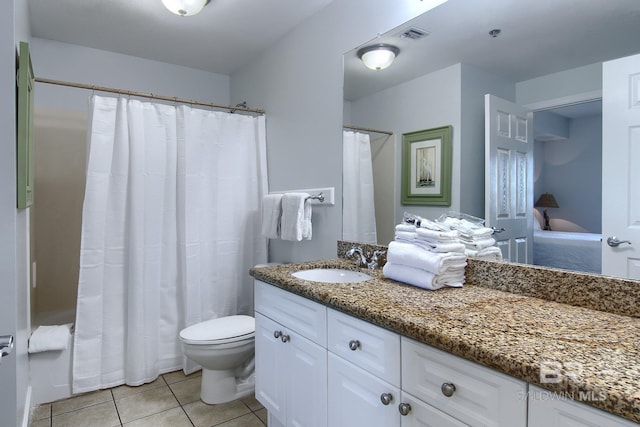 bathroom featuring tile patterned flooring, toilet, and vanity