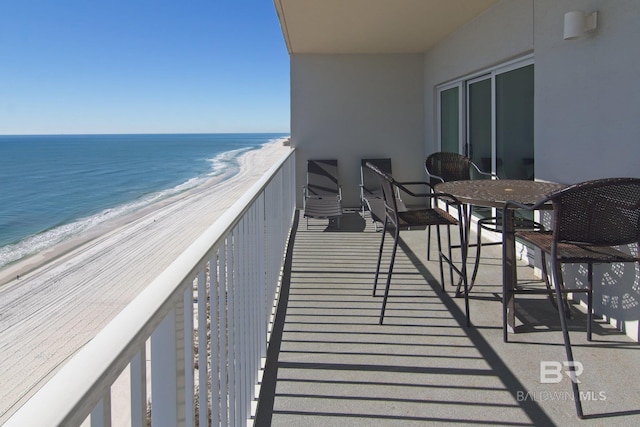 balcony featuring a water view and a beach view