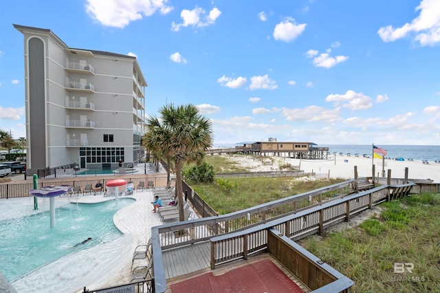 view of swimming pool with a patio, a water view, and pool water feature