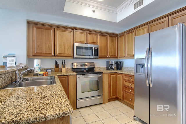 kitchen featuring a tray ceiling, crown molding, sink, appliances with stainless steel finishes, and light tile patterned floors