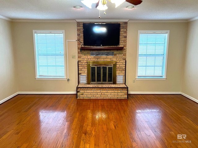 unfurnished living room featuring a brick fireplace, a textured ceiling, and plenty of natural light