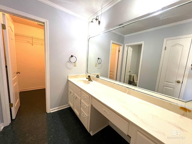 bathroom with a textured ceiling, crown molding, and vanity