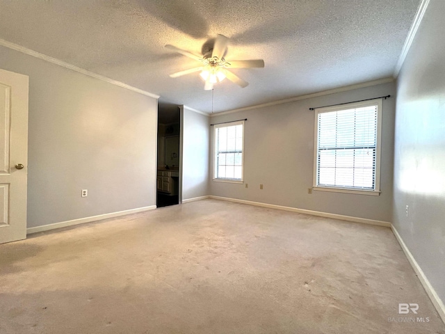 empty room with a textured ceiling, ceiling fan, ornamental molding, and light carpet