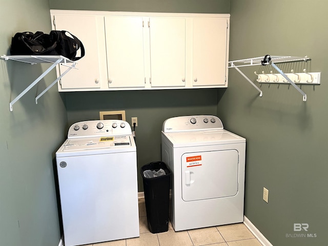 laundry room with light tile patterned flooring, cabinets, and independent washer and dryer