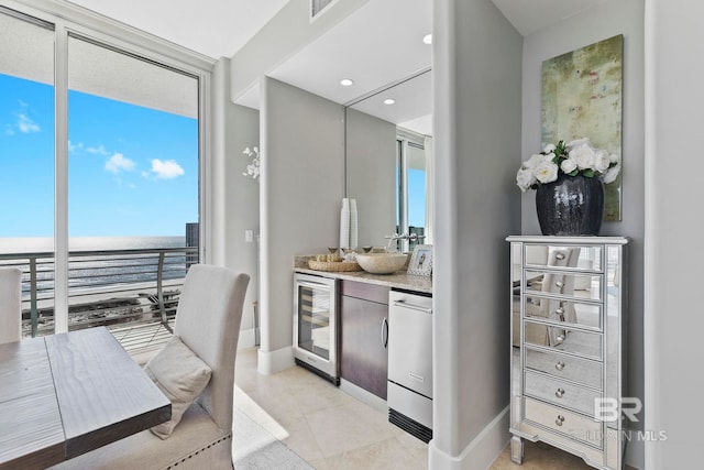 interior space featuring a water view, a wall of windows, wine cooler, and vanity