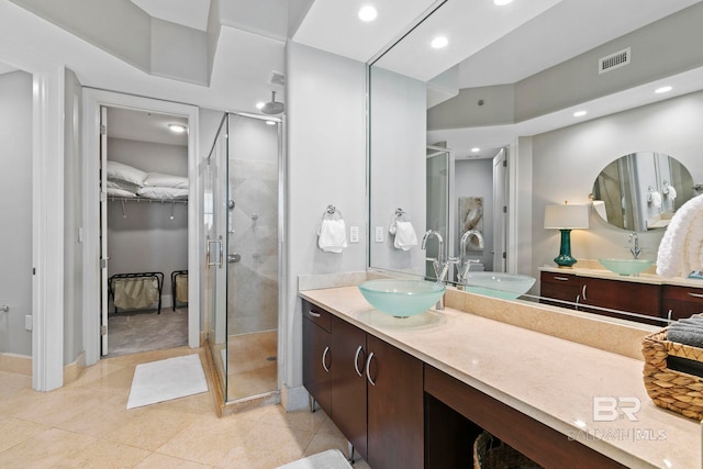 bathroom featuring a shower with shower door, vanity, and tile patterned flooring