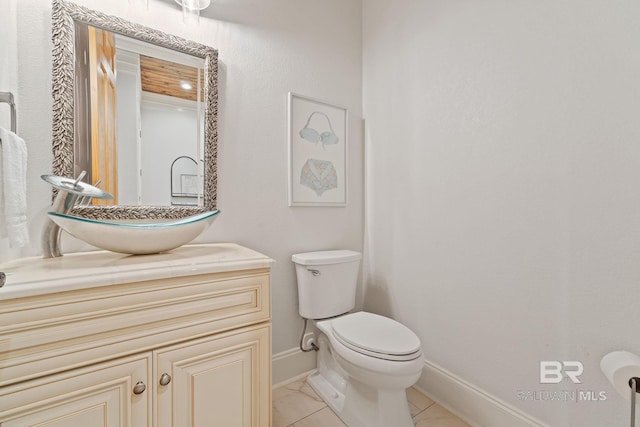 half bathroom with marble finish floor, toilet, vanity, and baseboards