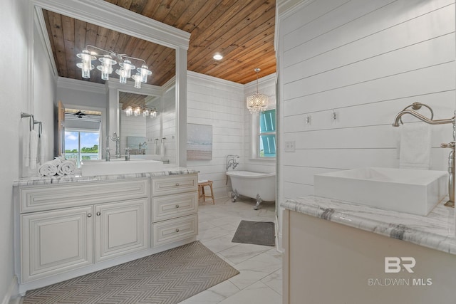 bathroom with a chandelier, marble finish floor, wood ceiling, a freestanding bath, and two vanities