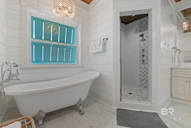 bathroom with a soaking tub, marble finish floor, a notable chandelier, and a stall shower