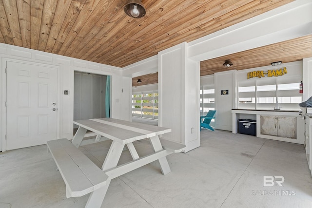 unfurnished dining area featuring elevator, concrete floors, and wood ceiling