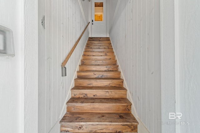 stairs featuring wood walls