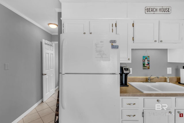 1118 W Beach Blvd Unit 4, Gulf Shores, AL 36542 - kitchen with freestanding refrigerator, ornamental molding, a sink, light tile patterned flooring, and white cabinets