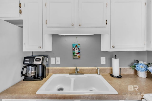 1118 W Beach Blvd Unit 4, Gulf Shores, AL 36542 - kitchen with light countertops, white cabinetry, and a sink