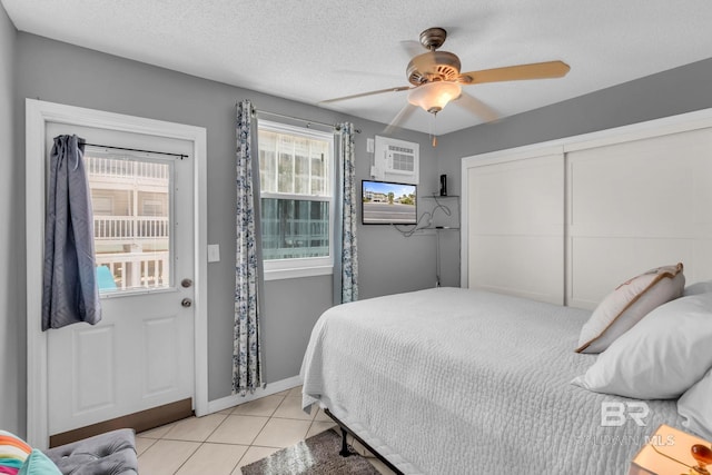 1118 W Beach Blvd Unit 4, Gulf Shores, AL 36542 - bedroom with tile patterned floors, a closet, a ceiling fan, baseboards, and a wall mounted air conditioner