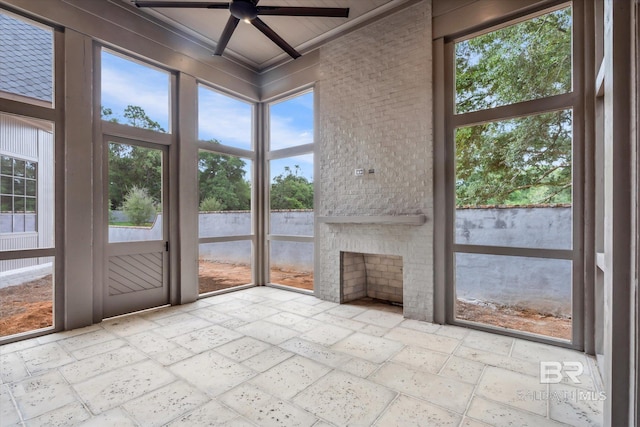 unfurnished sunroom with ceiling fan