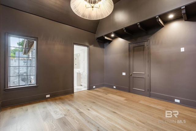 empty room with lofted ceiling and light hardwood / wood-style flooring