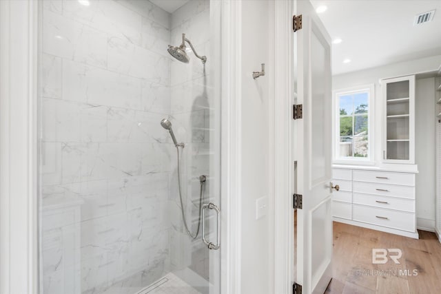 bathroom featuring hardwood / wood-style floors and tiled shower