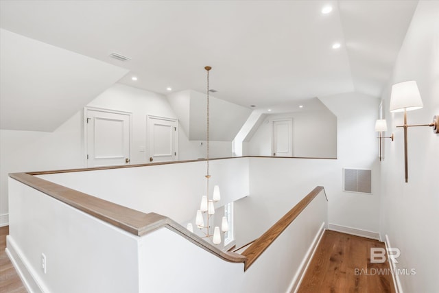 hallway with hardwood / wood-style flooring and vaulted ceiling