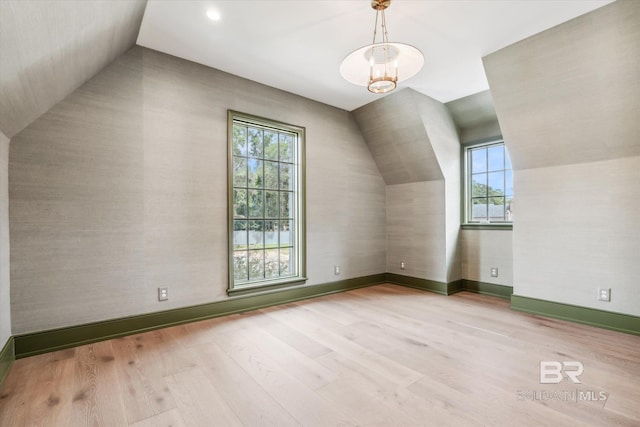 additional living space featuring lofted ceiling and light hardwood / wood-style flooring