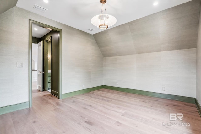 interior space featuring lofted ceiling, a chandelier, and light hardwood / wood-style flooring