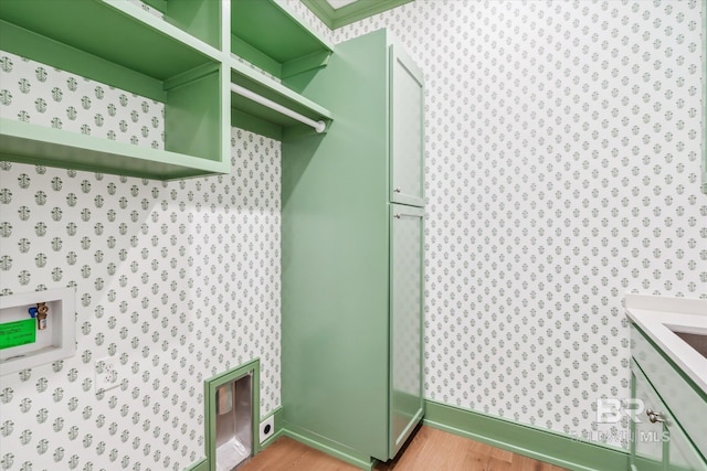 laundry room with cabinets, washer hookup, and light hardwood / wood-style floors