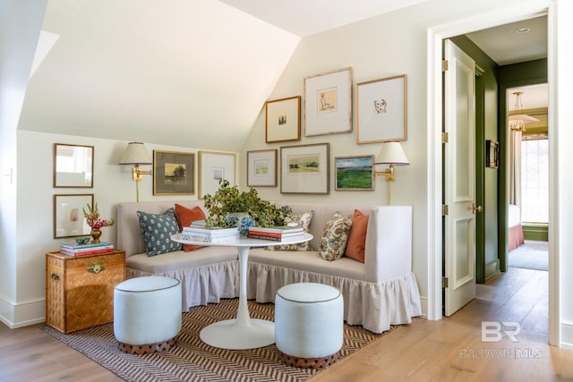 sitting room featuring breakfast area, lofted ceiling, and light hardwood / wood-style flooring