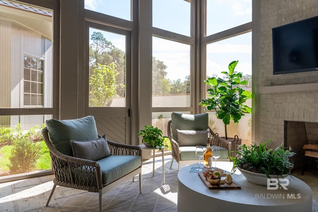 sunroom featuring a healthy amount of sunlight and a fireplace