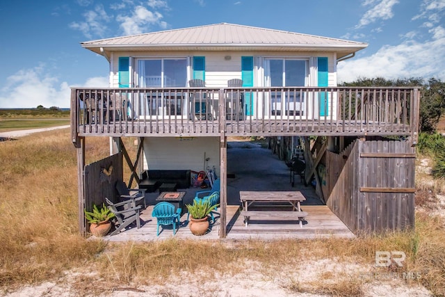 rear view of house featuring a patio, metal roof, and a wooden deck
