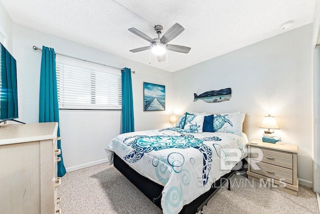 carpeted bedroom with a textured ceiling, ceiling fan, and baseboards