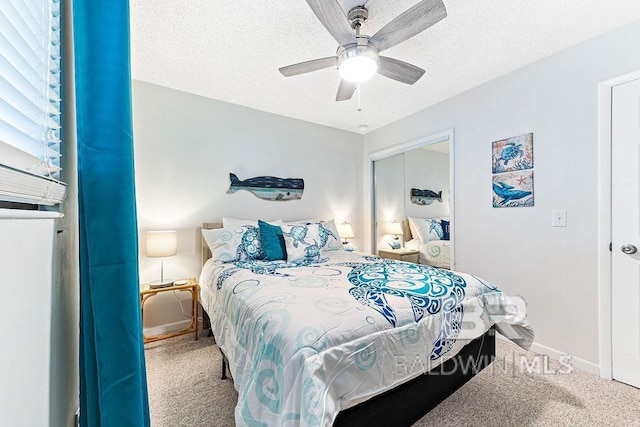 carpeted bedroom featuring baseboards, a ceiling fan, a closet, and a textured ceiling