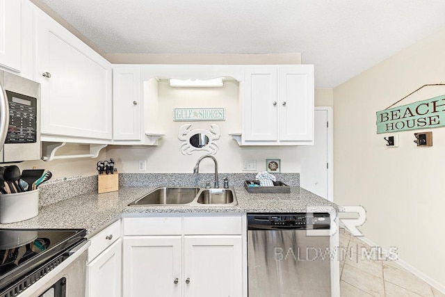 kitchen featuring a sink, tile patterned flooring, white cabinets, and stainless steel appliances