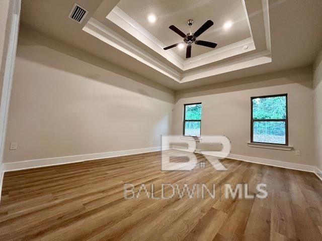 interior space featuring hardwood / wood-style floors, ceiling fan, and a tray ceiling