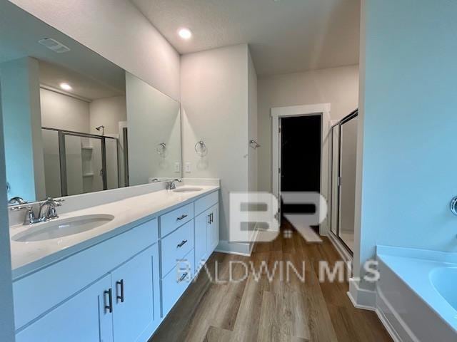 bathroom featuring shower with separate bathtub, vanity, and wood-type flooring