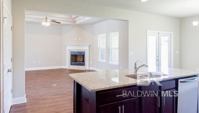 kitchen featuring light stone countertops, sink, hardwood / wood-style floors, an island with sink, and ceiling fan