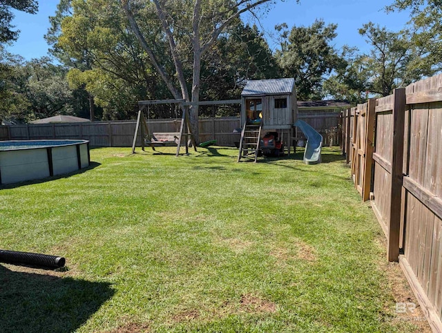 view of yard with a fenced in pool and a playground