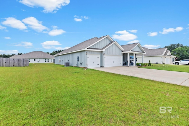 view of front of house featuring a garage, cooling unit, and a front lawn