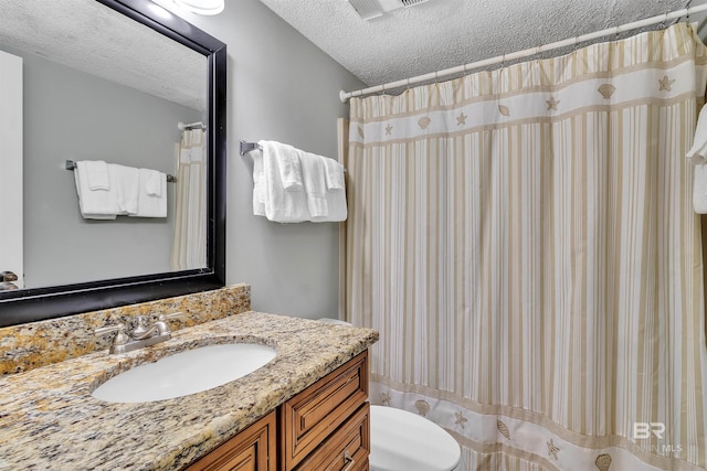 bathroom featuring toilet, a textured ceiling, vanity, and a shower with curtain