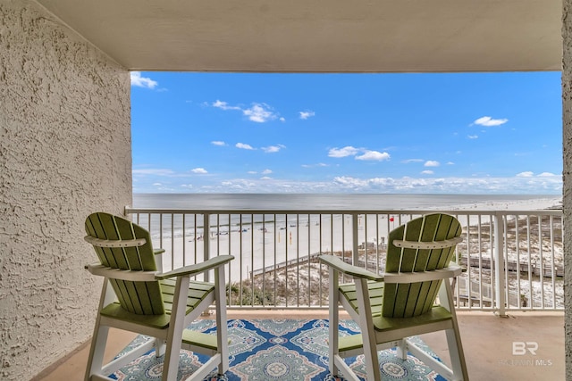 balcony with a water view and a beach view