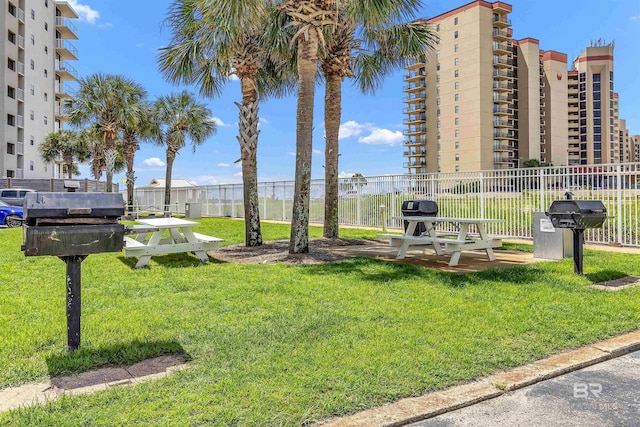 view of home's community with a yard and fence