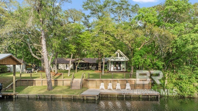 back of property with a yard and a water view