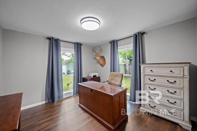 home office featuring baseboards, dark wood finished floors, and a textured ceiling