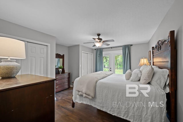 bedroom featuring two closets, access to outside, dark wood-style floors, and a ceiling fan