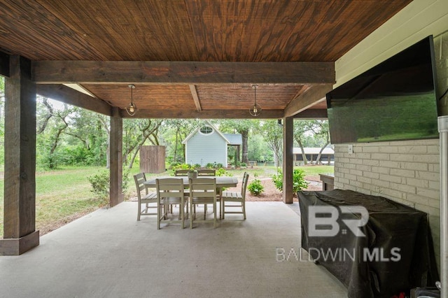 view of patio / terrace with an outdoor structure, outdoor dining space, and a storage unit