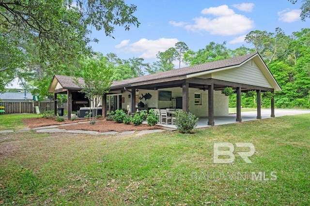 rear view of property with a yard, a ceiling fan, fence, a patio, and a shingled roof