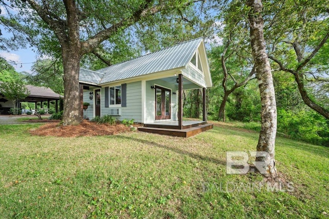view of home's exterior featuring metal roof, ceiling fan, and a lawn