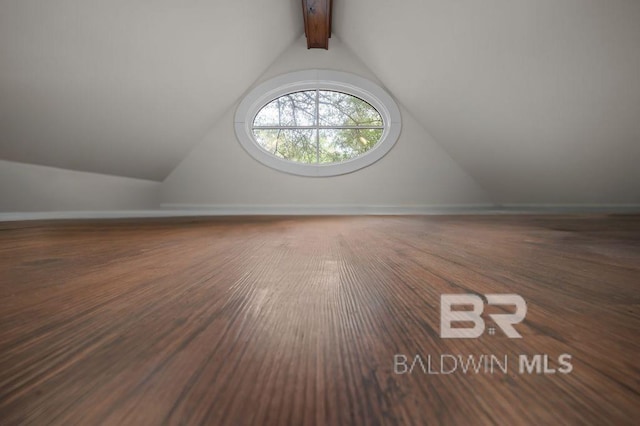 bonus room with baseboards, lofted ceiling with beams, and wood finished floors