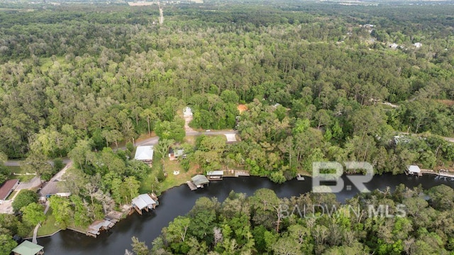 drone / aerial view with a wooded view and a water view