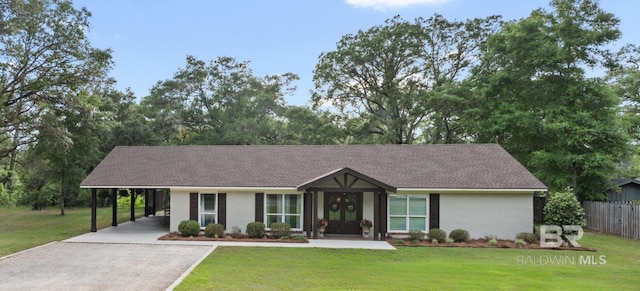 ranch-style house featuring a front lawn, driveway, fence, and a carport