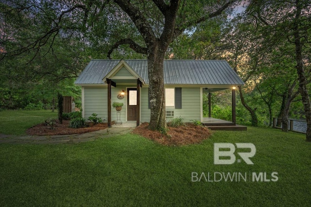 view of front of house featuring metal roof, a porch, and a front lawn